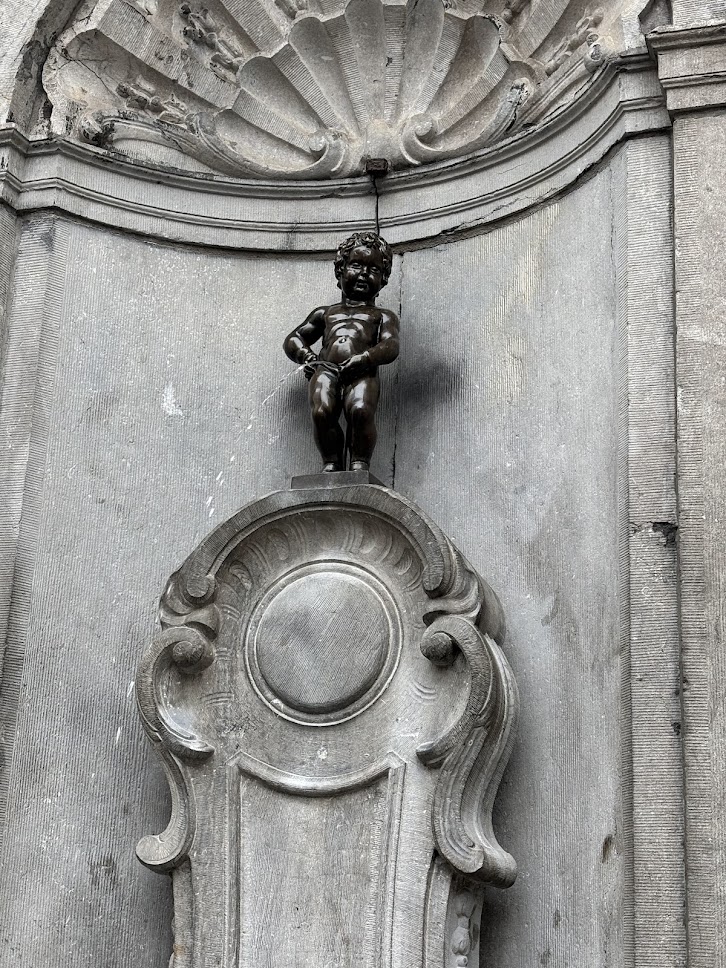 A dwarf statue with a camera taking photos