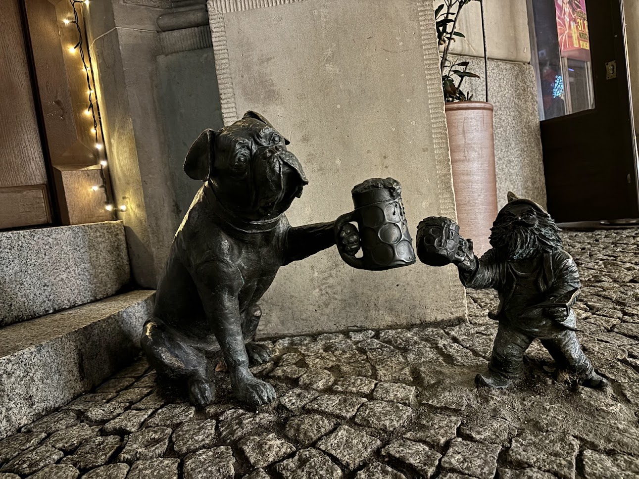 A dwarf statue climbing up a lamppost in Wrocław