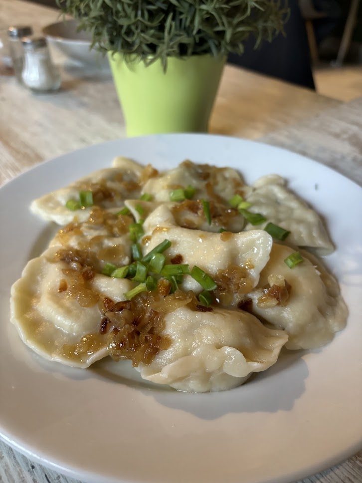 A plate of pierogi dumplings served with herbs